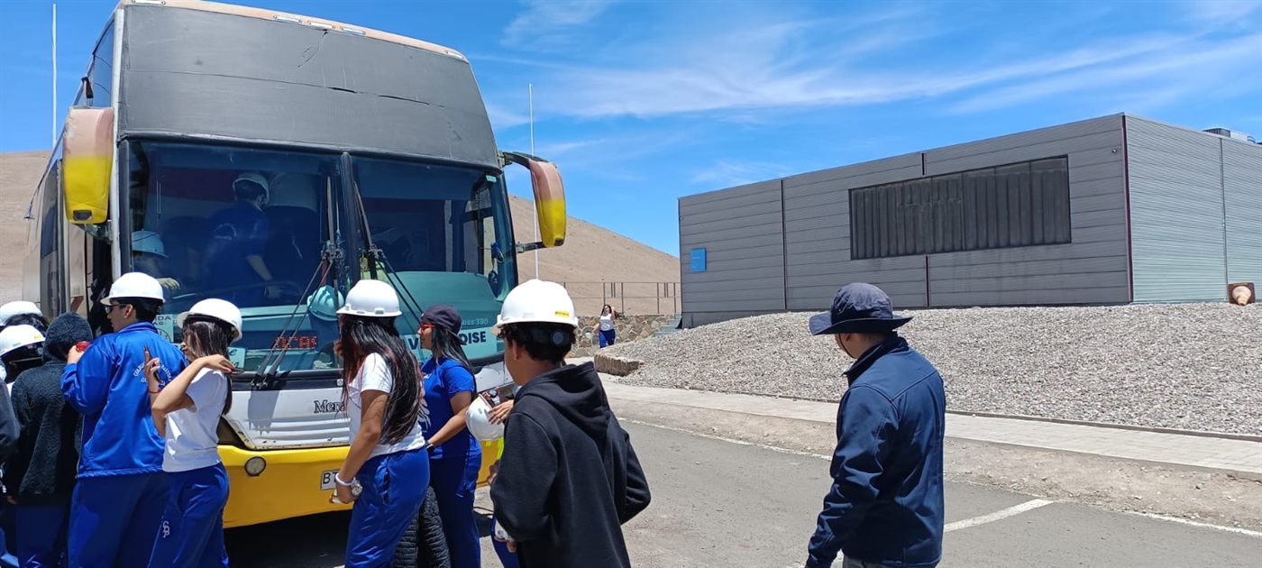 Grupo con cascos junto a bus en zona industrial