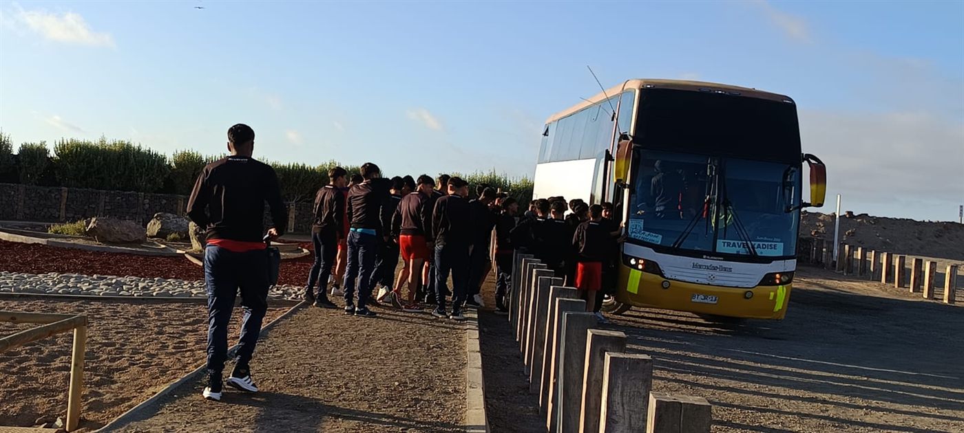 Grupo esperando embarque junto al bus